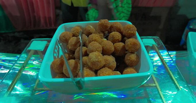 Delicious Indian sweets like laddoo, gulab jamun, dahiwada, rabadi, rasgulla, and kaju katli beautifully displayed by caterers during a festive event