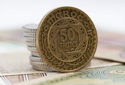 Moroccan 50 francs coin, standing upright on a stack, with intricate Arabic and geometric designs