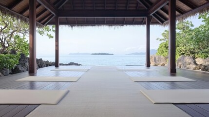 Open-air yoga pavilion facing the ocean with mats on wooden deck