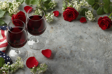 Two Glasses of Red Wine with Red Roses and White Flowers on a Gray Textured Surface Near an American Flag