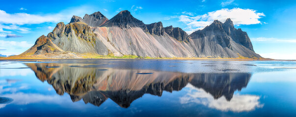 Amazing  sunny day and gorgeous reflection of Vestrahorn mountaine on Stokksnes cape in Iceland.