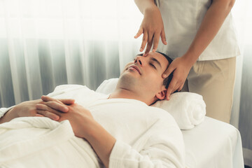Caucasian man enjoying relaxing anti-stress head massage and pampering facial beauty skin...