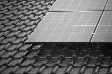 Corner of solar panel array on tiled roof in heavy rain  
