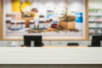 Empty wooden counter with copy space in front of blurred pharmacy shelves with medicines. Pharmaceutical promotions, medical branding, natural remedies, healthcare, treatment and wellness concept.