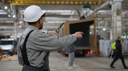 Construction site manager guiding prefabricated house module transportation