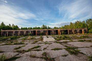 Old abandoned overgrown truck or tractor garages