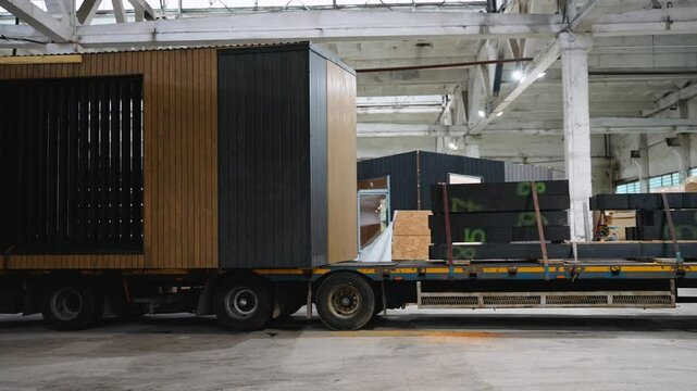 Prefabricated tiny house leaving factory loaded on flatbed truck