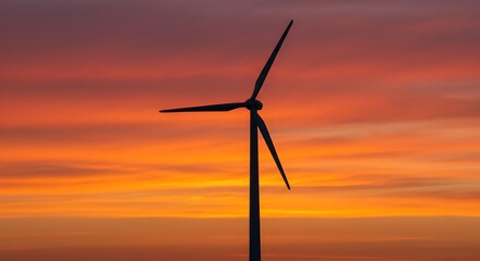 Fototapeta premium Wind turbine silhouette against orange sunset