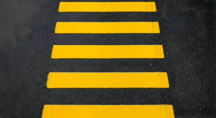 High-angle view of yellow pedestrian zebra crossing on asphalt road surface for road safety concept crossing mark