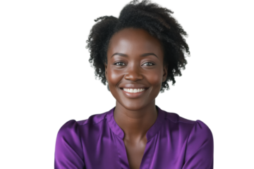 A smiling Black woman with curly hair gazes directly at the camera, wearing a purple top against a soft gray background.