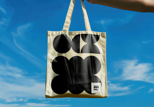 Tote Bag Mockup Held Up Against Blue Sky
