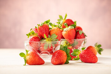 Strawberries, glass jars with beautiful strawberries on a white rustic wooden surface, abstract background, selective focus.