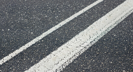 Macro shot showcases asphalt road surface with cracked white road marking lines