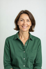 A smiling woman with shoulder-length brown hair looks directly at the camera, wearing a dark green shirt against a neutral background.