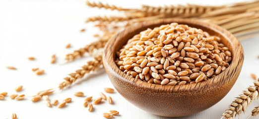 Wheat grains in wooden bowl with wheat stalks on white background.