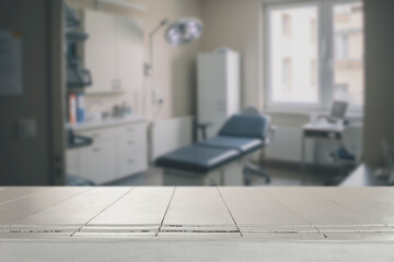 Empty wooden table with copy space in front of blurred doctor's office interior. Preventive care,...