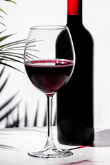 Non-alcoholic red wine served elegantly in a crystal glass against a minimalist background with a wine bottle
