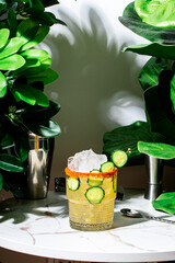Refreshing spicy cucumber margarita with jalapeno and chili salt served in a vibrant green setting