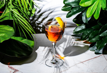 refreshing La Perla cocktail amidst vibrant greenery at a modern bar lounge setting