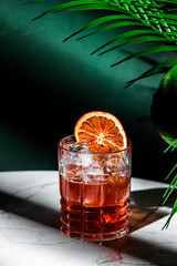 Iced Caramel Coffee alcoholic cocktail drink with vodka, cold coffee, dry orange and ice. Green...