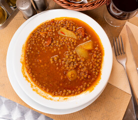 Lentil soup with potatoes and smoked chorrizo sausage. Spanish traditional dish