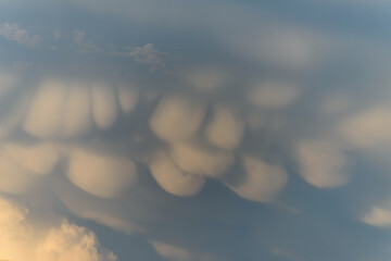 Unique cloud formations display dramatic textures during sunset over the landscape
