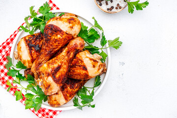 Baked chicken legs or drumsticks, white table background, top view