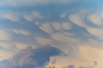 Unique cloud formations display dramatic textures during sunset over the landscape