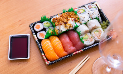 Restaurant serving of dishes - uramaki rolls and nigiri decorated with imitation of green spring...