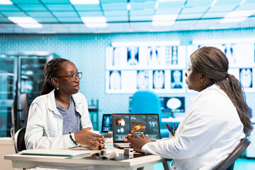 Female physician conducting a routine checkup with young patient, analyzing diagnostics and...