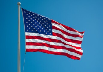 Fototapeta premium American Flag Waving Proudly Against Clear Blue Sky, A Symbol of Freedom and National Pride