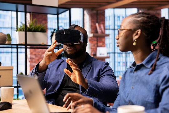 Black people integrates VR and AI into their daily routine where the man engages in immersive 3D experience. Young focused woman managing the animation within the metaverse on laptop.