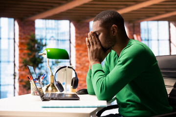 Gamer annoyed after losing online videogame on laptop at home, being defeated by rivals. Man doing...
