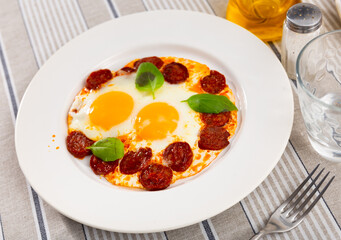 Delicious fried eggs with chorizo sausage served for breakfast