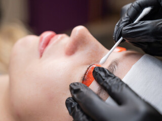 Caucasian woman undergoing eyelash lamination procedure. 