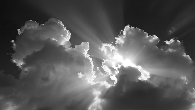 Dramatic sun rays bursting through dark storm clouds in black and white