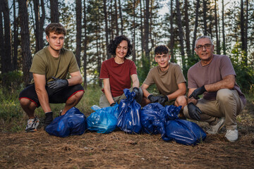 portrait of family of volunteers pick up waste garbage to clean forest