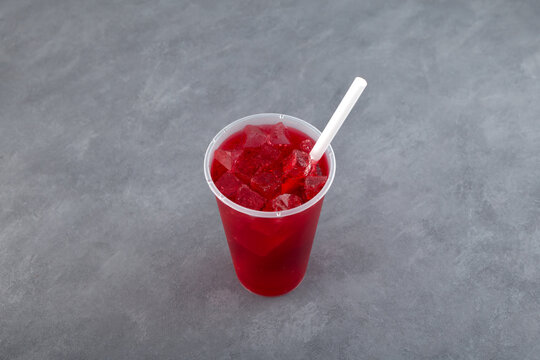 Agua de Jamaica or Jamaica drink. Trendy refreshing summer ice drink in disposable plastic cup. Red hibiscus ice tea. Karkade chai with ice cubes