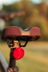 Bicycle seat with red light reflector in nature in summer