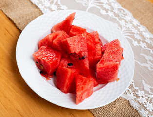 Service plate containing fresh watermelon pieces with other table appointments