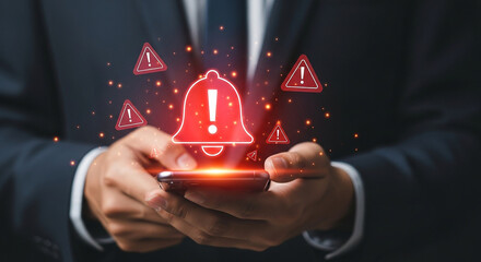 Man holding a smartphone displaying a glowing red alert notification with warning symbols, signifying urgent communication