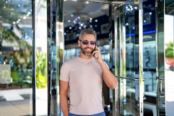Man reply phone call. Casual businessman talking on phone outdoor. Businessman using phone. Man...