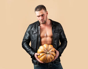 Autumn fall. male concept. Halloween man. Athletic muscular man hold pumpkin. Sexy male Halloween...