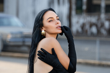 Portrait of Beautiful brunette woman posing on the street. Close-up Fashion woman portrait of young...