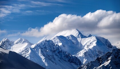 Fototapeta premium majestic snow covered mountain range under a bright blue sky with drifting clouds