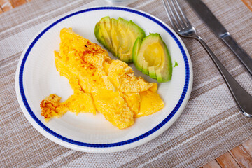 Omelet served with fresh avocado on plate for breakfast