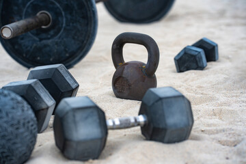 Sports equipment. Dumbbells background. Dumbbell on the beach for summer sport. Dumbbells in sand....