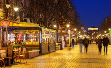 People walk along the evening busy Vitosha Boulevard in the city of Sofia, Bulgaria