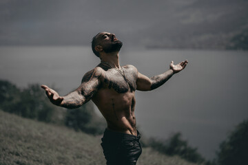 Carefree man in nature. Freedom man in alpine landscape. Muscular model breathing air near...