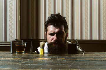 Razor sharp. Barber Shop Studios. Bearded man getting haircut by hairdresser and sitting in chair...